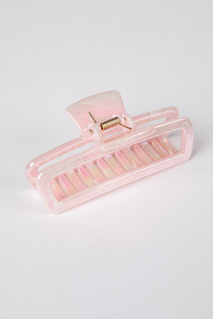 Pink hair clip on a light gray background