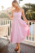 Woman in a pink dress standing on a balcony with a scenic background