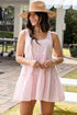 Woman wearing a pink dress and straw hat outdoors