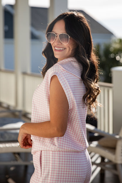 woman wearing a pink gingham quarter zip collared tank top