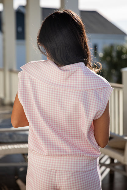 woman wearing a pink gingham quarter zip collared tank top
