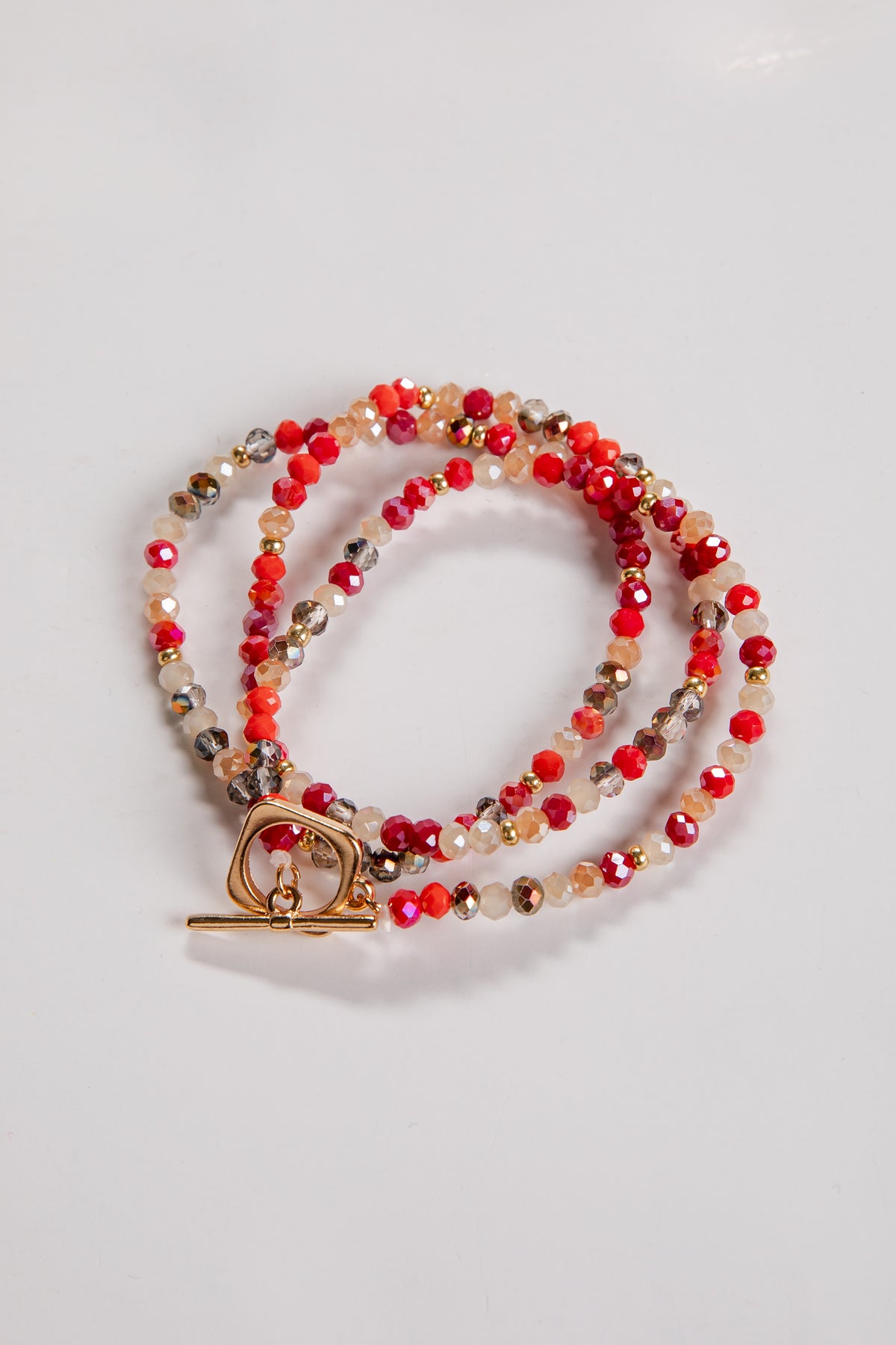 Beaded necklace with a gold clasp on a light gray background