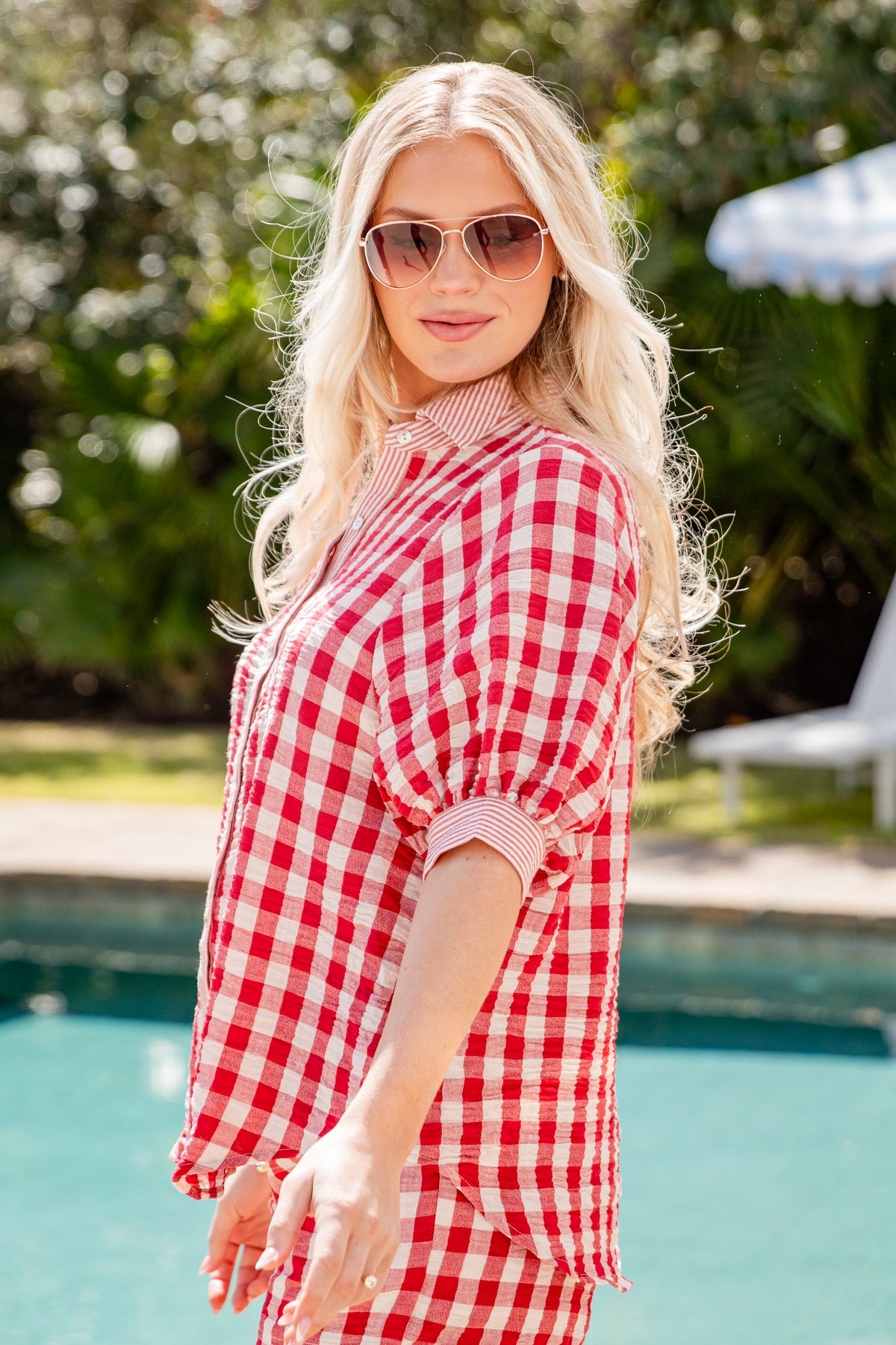 Woman wearing a red and white checkered outfit by a pool