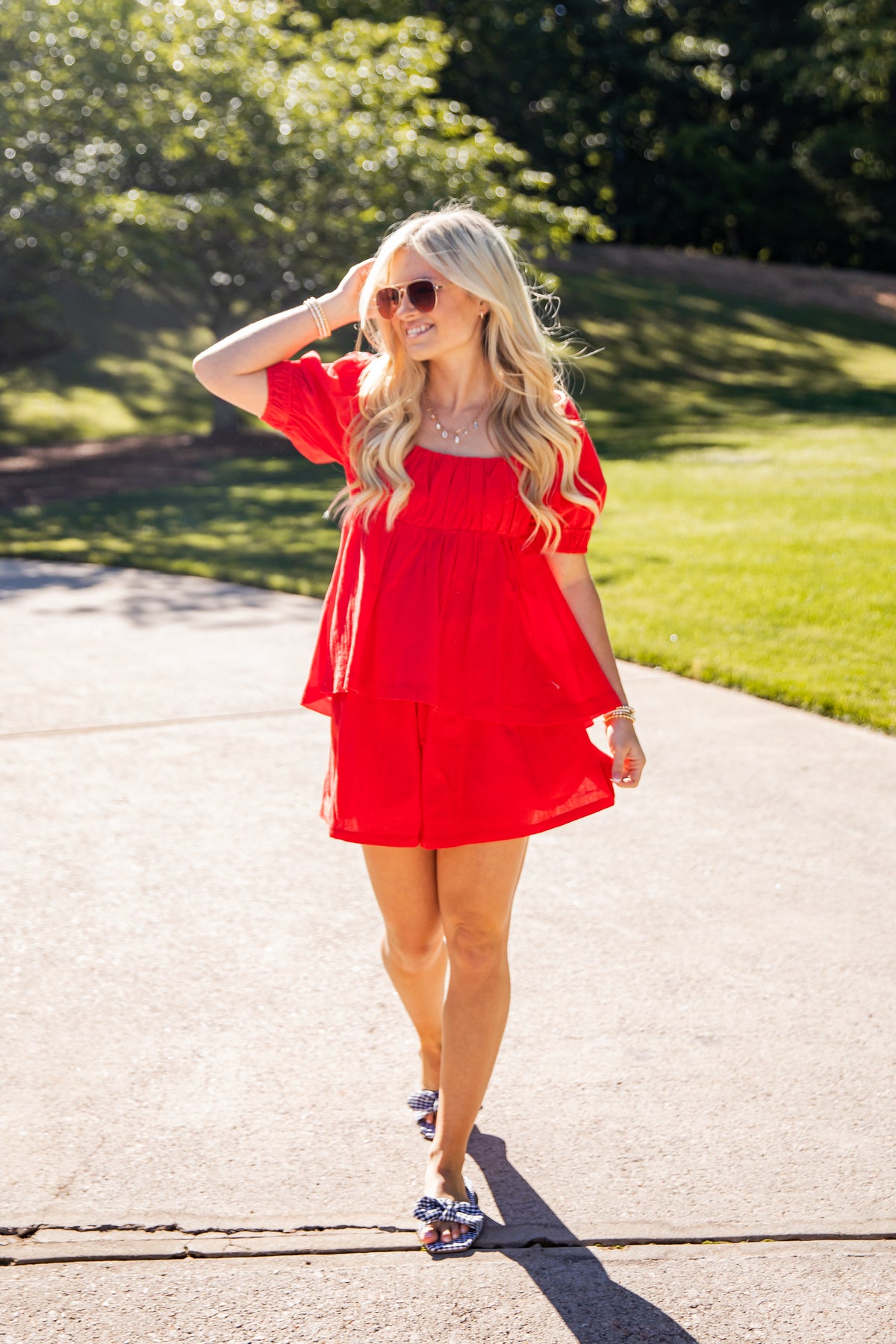 Woman in a red dress walking outdoors on a sunny day