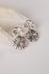 Silver shell-shaped earrings on a light background