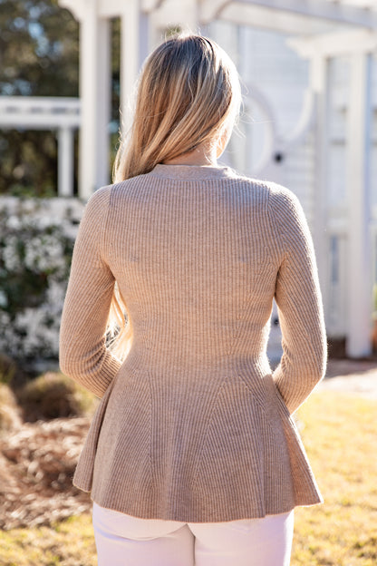 Woman wearing a beige peplum jacket outdoors