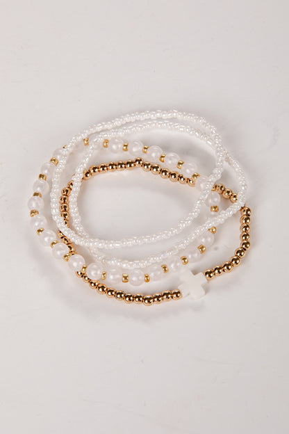 Set of pearl and gold beaded bracelets on a light background