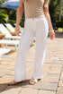 Person wearing a beige top and white pants on a patio