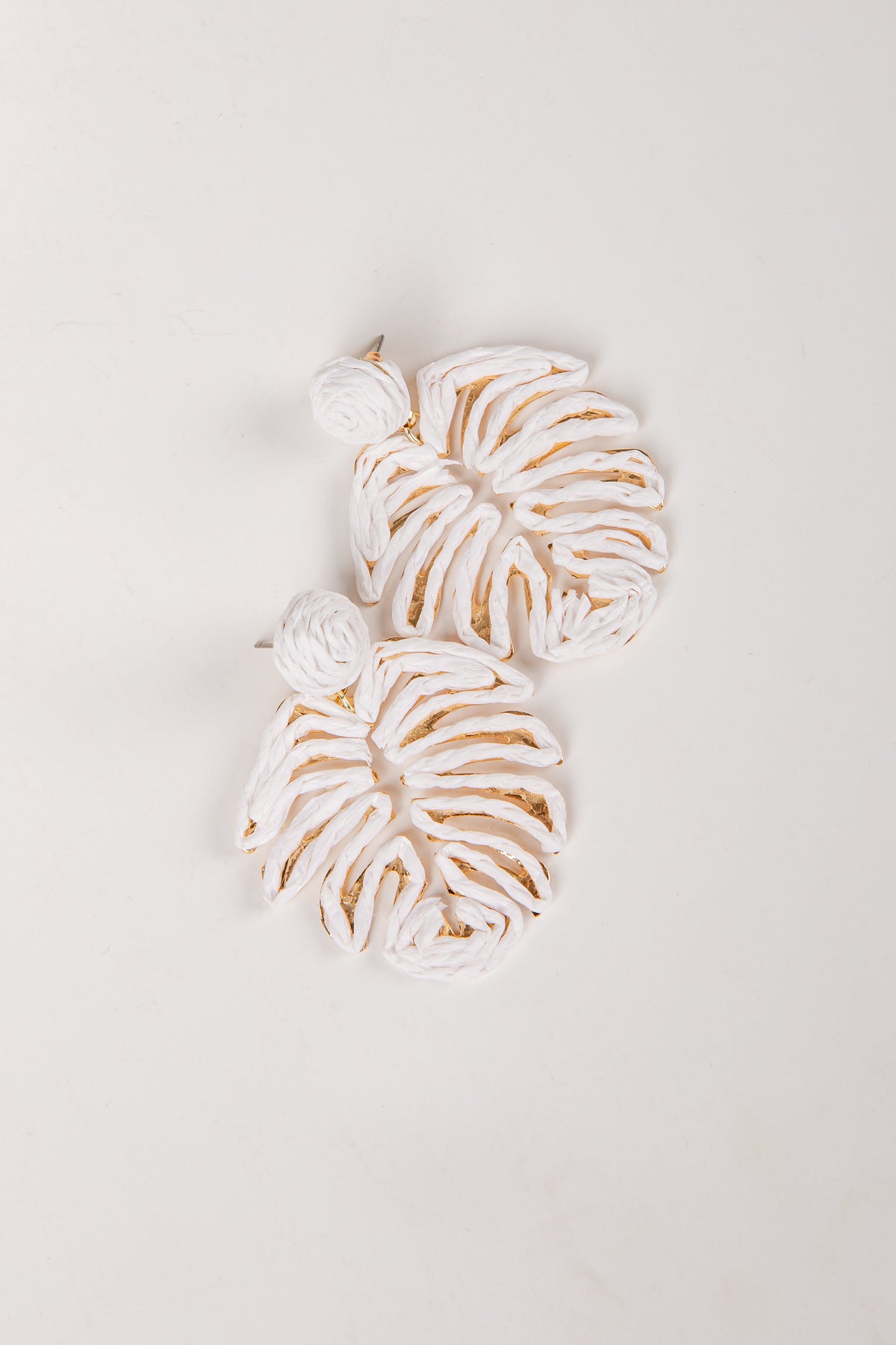 Decorative leaf-shaped cookies with white icing on a light gray background