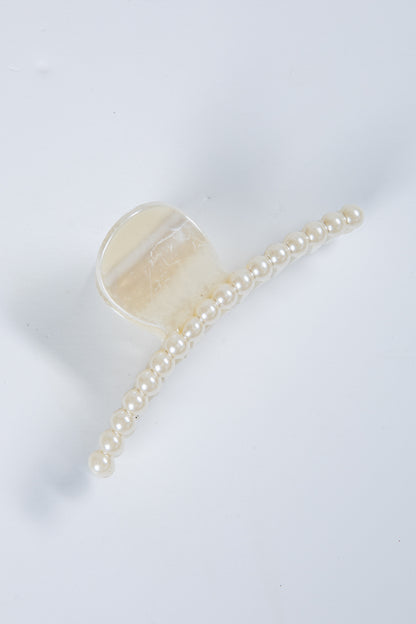 Transparent hair clip with a chain of pearls on a white background