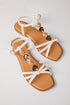 Tan sandals with white straps and gold heart embellishments on a light gray background