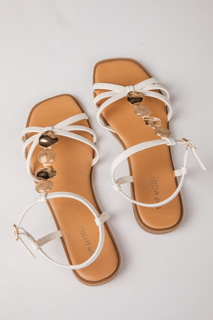 Pair of tan sandals with white straps on a light gray background