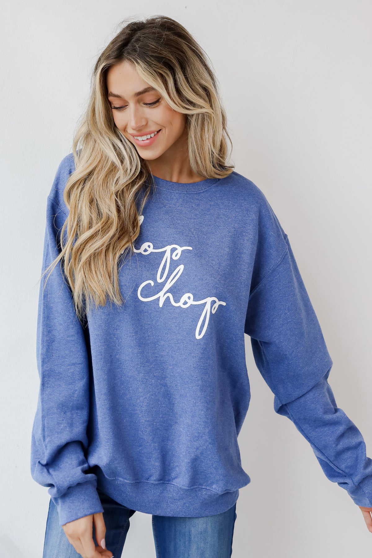 This comfy sweatshirt is designed with a soft and stretchy knit with a fleece interior. It features a crew neckline, long sleeves, a relaxed fit, and the words "Chop Chop" on the front. 