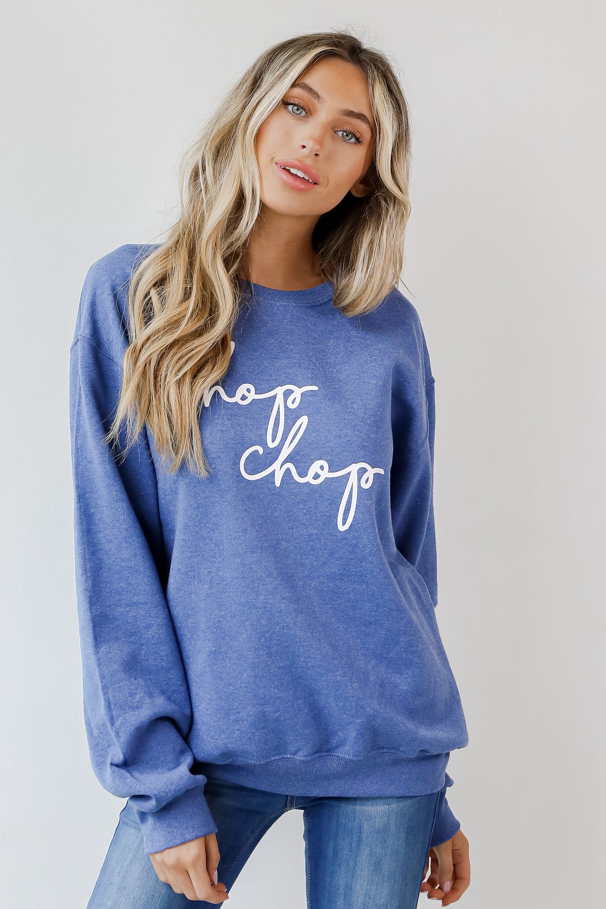 This comfy sweatshirt is designed with a soft and stretchy knit with a fleece interior. It features a crew neckline, long sleeves, a relaxed fit, and the words "Chop Chop" on the front. 